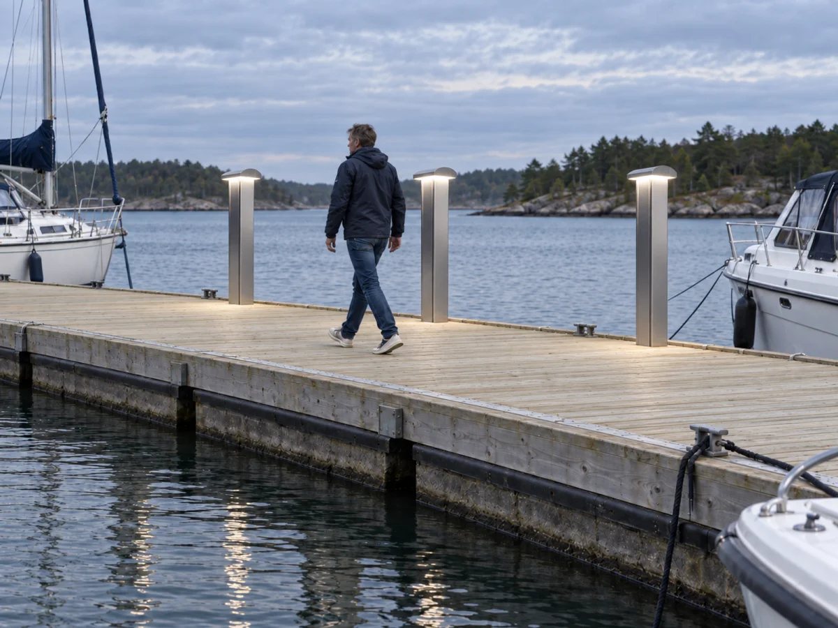 Marinella NEO Light bollards along a marina pontoon in daylight, with a visitor walking past the moored yachts.