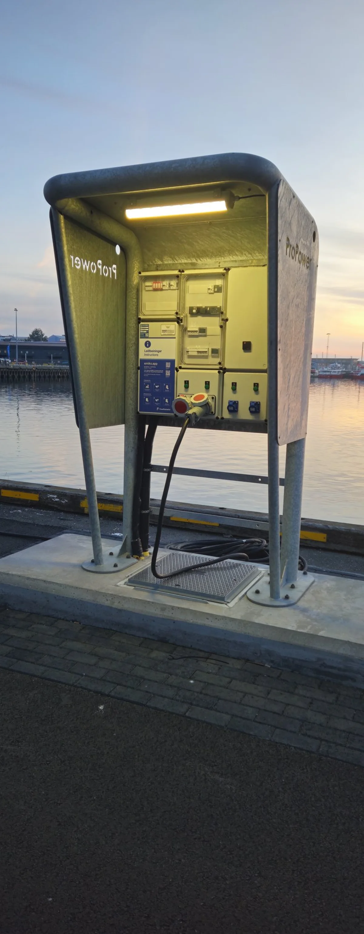 MarinePro pedestal at the quay edge, looking out over the calm harbour water towards the far pier.