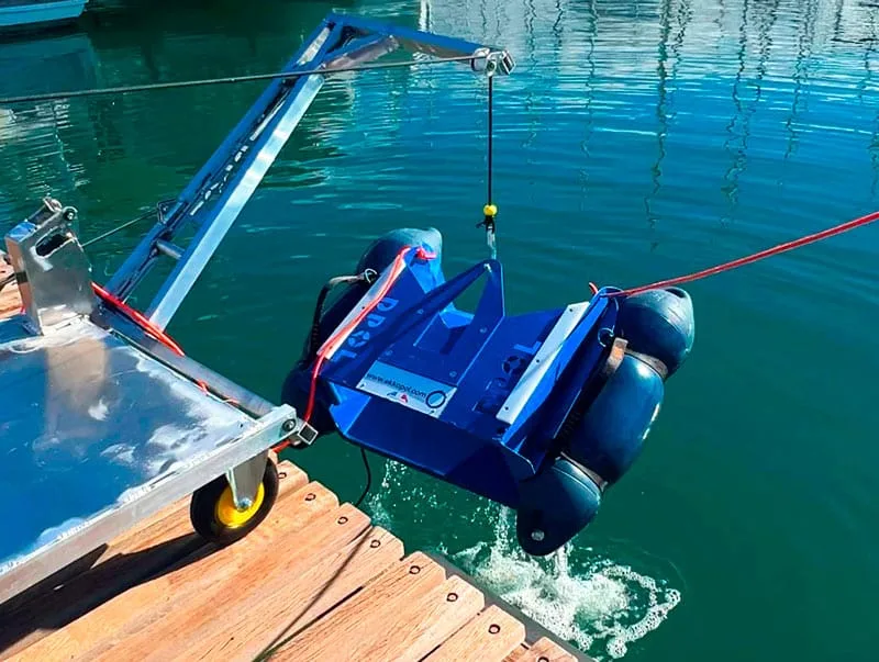 En DPOL-robot sænkes ned i vandet med en kran fra molen.