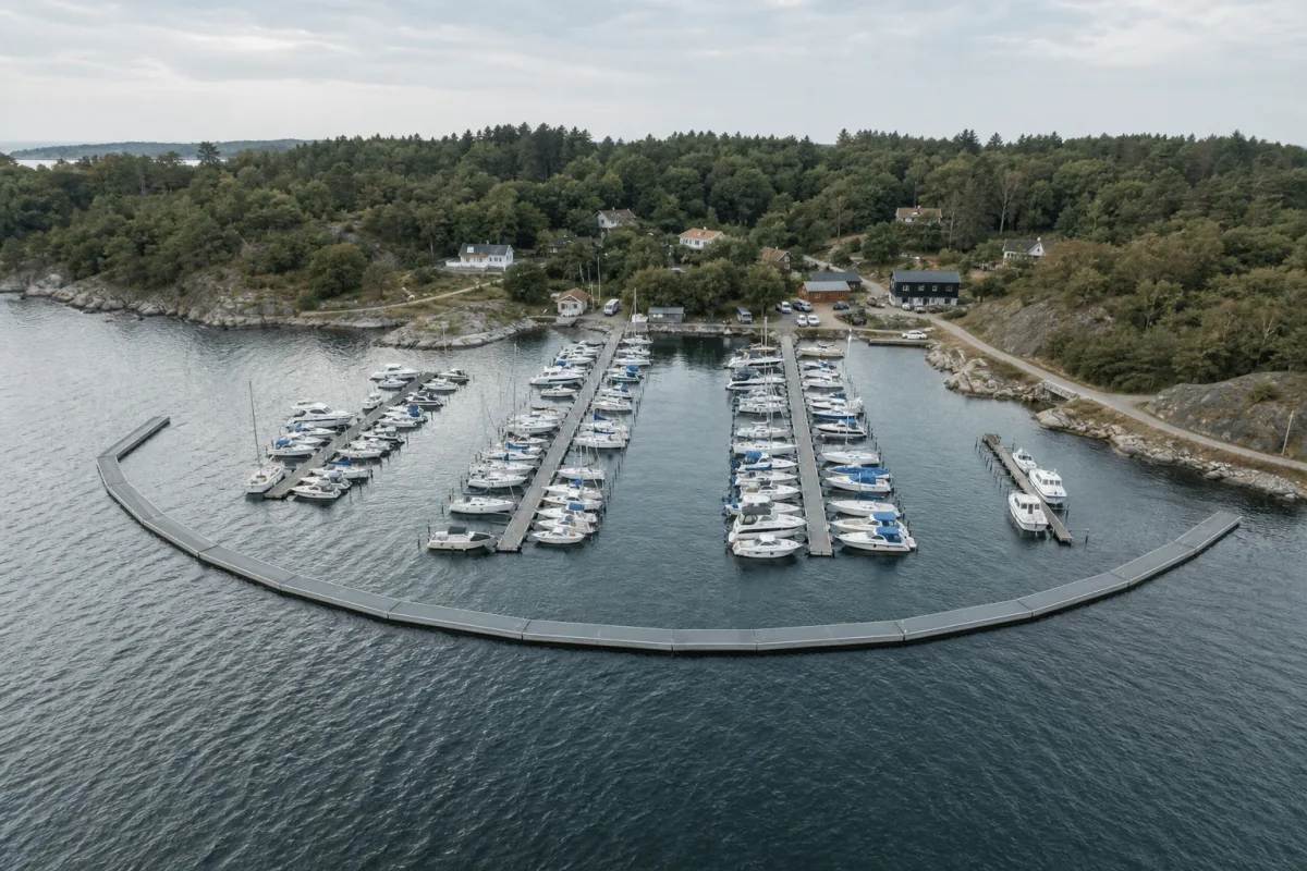 Aerial view of a Vikingegaarden floating breakwater curving around and protecting a Nordic marina.