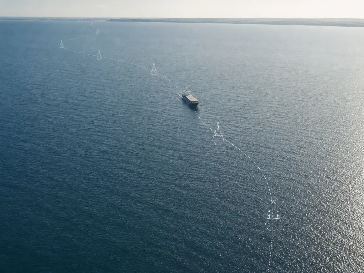Aerial view of a dotted virtual fairway crossing open water, with ghost marks at intervals and a vessel between them.