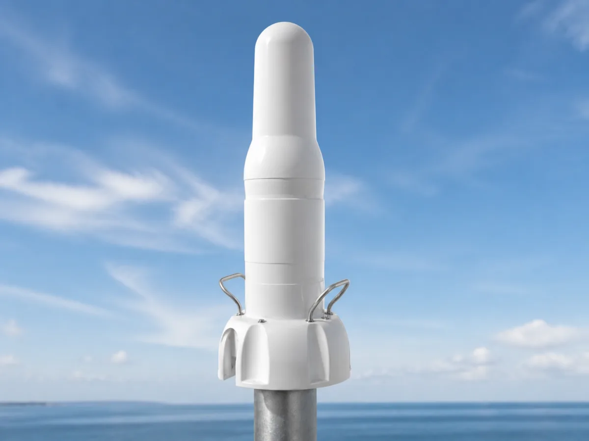 HEKLEO 2 XS radar beacon, the plain white radome with lifting handles, bracket-mounted against a coastal sky.