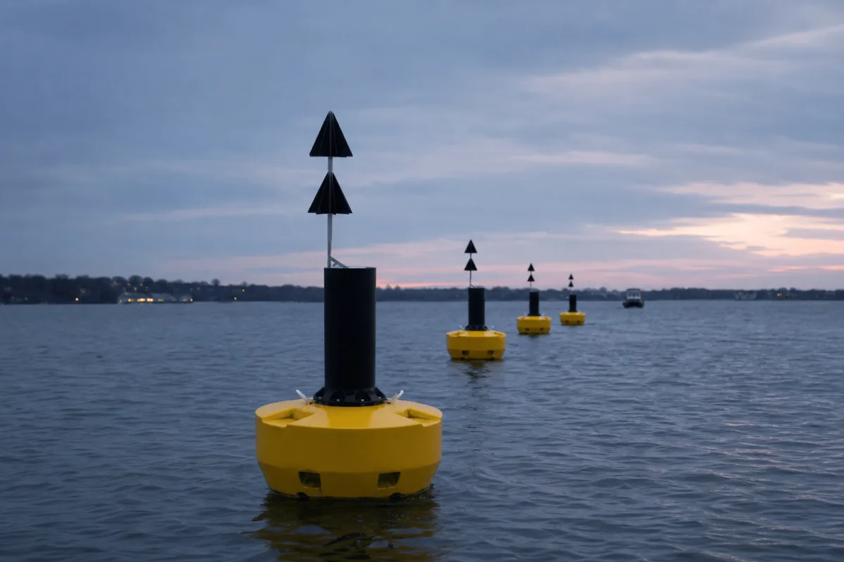 Physical Buoys FLC navigation buoys receding in a row along a Danish fairway at dusk.