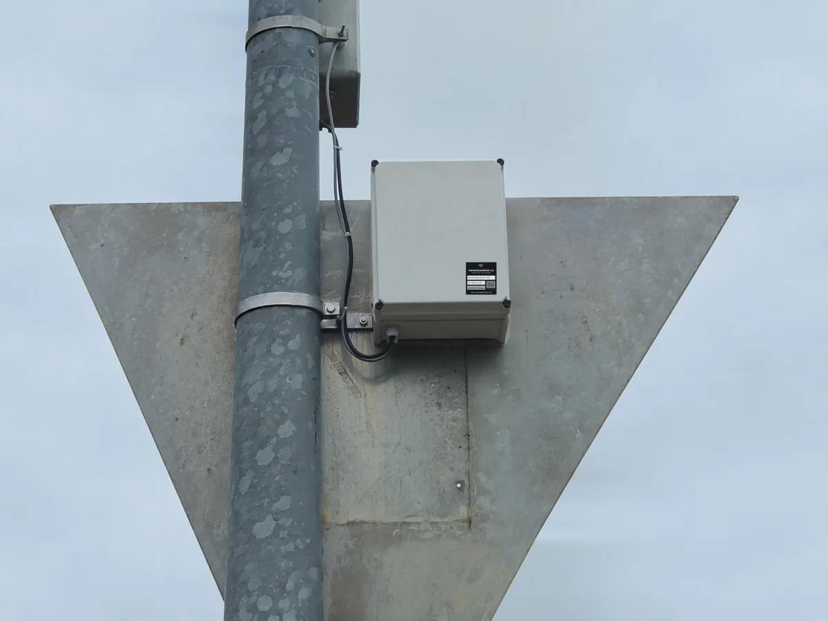 Close view of the PowerGuard enclosure bolted to the back of a daymark, with its cable running down the concrete post.