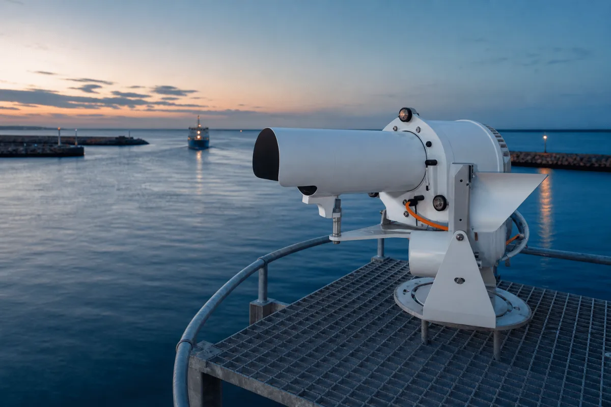 A directional range light points along the harbor entrance from its adjustable pier-head mount at dusk.