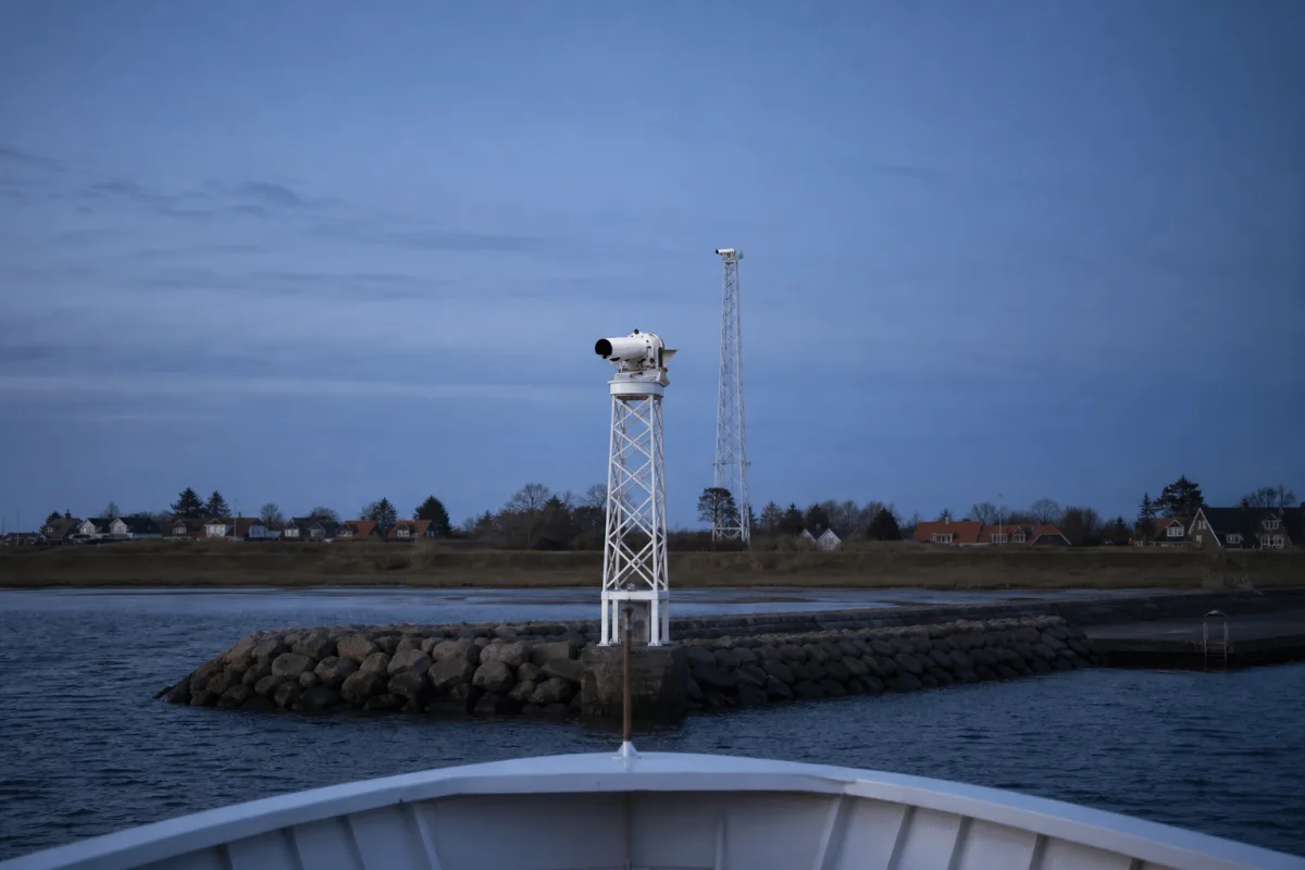 Two directional lead lights form an approach line beyond the bow of an arriving vessel.