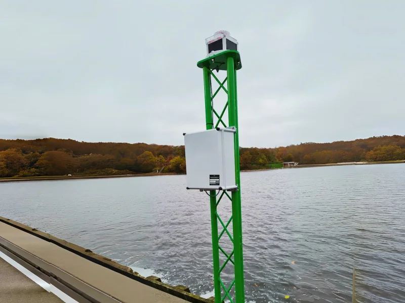En PowerGuard-strømforsyning på en grøn gittermast med et lys, der står i vandet